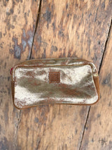 Photo of front of metallic gold leather cosmetic bag with leather sts patch on front