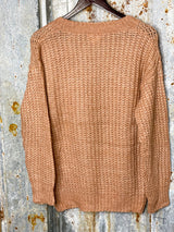 Photo of back of light rose pink knit sweater hanging on a hanger with tin background