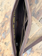 Photo of inside of dark brown wallet clutch with zipper pocket and card slots